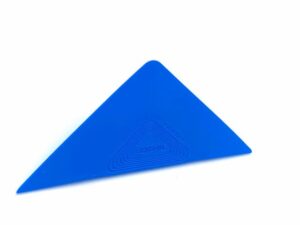 A blue triangle is sitting on top of the floor.