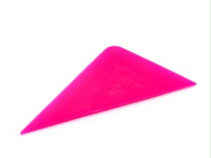A pink plastic object is sitting on top of the floor.