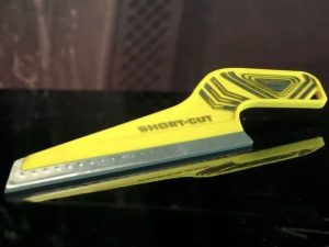 A yellow and black short cut knife on top of a table.