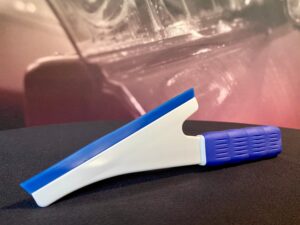 A blue and white plastic knife on top of a table.