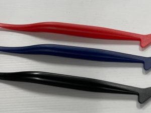 Three different colored pens are sitting on a table.