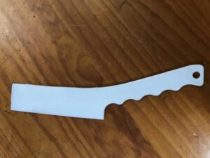 A white knife is laying on the table
