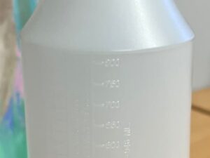 A bottle of liquid with a measuring cup on top.