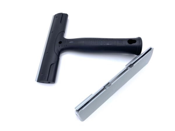 A black and silver squeegee on top of a white surface.